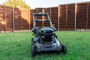An electric lawn mower machine over the green lawn