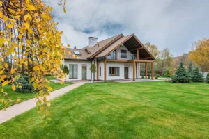 A beautiful house with a green lawn in fall autumn