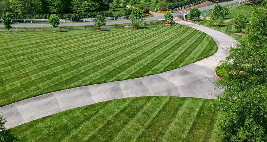Professionally maintained commercial lawn with striped mowing pattern and clean driveway in Cumming GA