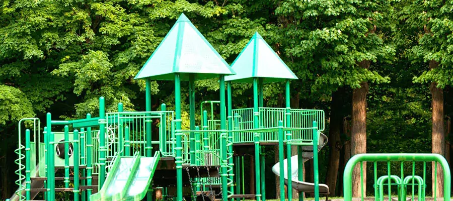 Kids' playground in front of big green trees